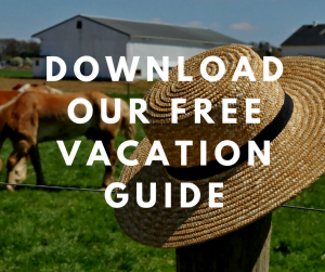 Straw hat on a fence and farm in the background with text saying "Download our free Vacation Guide"